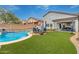 Expansive backyard featuring a sparkling pool, lush artificial turf, and a covered patio for outdoor enjoyment at 4514 E Coyote Wash Dr, Cave Creek, AZ 85331