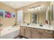 Well-lit bathroom featuring double sinks, a glass block window, and a soaking tub at 4514 E Coyote Wash Dr, Cave Creek, AZ 85331