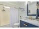 Well-lit bathroom with a blue vanity, marble countertop, and bathtub with shower at 4514 E Coyote Wash Dr, Cave Creek, AZ 85331