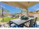 Inviting covered patio with dining table overlooks the backyard's pool, lush lawn, and desert landscape at 4514 E Coyote Wash Dr, Cave Creek, AZ 85331
