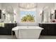 Modern bathroom with a soaking tub between -and- vanities and large window at 528 E Ashurst Dr, Phoenix, AZ 85048