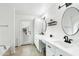 Bright bathroom with dual sinks, white cabinets, sleek black fixtures and a walkout door at 5850 E Le Marche Ave, Scottsdale, AZ 85254