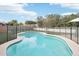 A beautiful in-ground pool surrounded by artificial grass and a secure safety fence at 5850 E Le Marche Ave, Scottsdale, AZ 85254