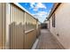 Side view of a home showing storage area with metal siding and brick paver walkway at 5932 W Poinsettia Dr, Glendale, AZ 85304