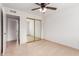 Bedroom with mirrored closet doors, tile flooring, and a glimpse into the hallway at 6031 W Hearn Rd, Glendale, AZ 85306