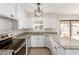 Kitchen features white cabinets, granite counters, and stainless steel appliances at 6031 W Hearn Rd, Glendale, AZ 85306