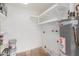 Functional laundry room with utility sink, water heater, and shelving, maximizing space for household tasks at 6031 W Hearn Rd, Glendale, AZ 85306