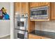 Close-up of stainless steel appliances with wooden cabinetry in the kitchen at 6240 E Ironwood Dr, Scottsdale, AZ 85266