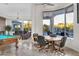 Open-concept living room featuring a pool table, fireplace, and scenic backyard views at 6240 E Ironwood Dr, Scottsdale, AZ 85266