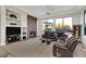 Open-concept living room with a stone fireplace, large windows, and comfortable leather seating at 6240 E Ironwood Dr, Scottsdale, AZ 85266