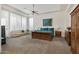 This primary bedroom features tray ceilings, a ceiling fan, and an ensuite seating area at 6240 E Ironwood Dr, Scottsdale, AZ 85266