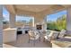 Spacious outdoor kitchen with built-in grill, sink, fireplace, and comfortable seating area at 6240 E Ironwood Dr, Scottsdale, AZ 85266
