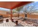 Backyard featuring covered patio, desert landscaping, and wooden bridge in a desert neighborhood at 640 E Desert Canyon Rd, Wickenburg, AZ 85390