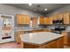 Well-lit kitchen with wood cabinets, island with gray countertop and door leading to outdoor area at 640 E Desert Canyon Rd, Wickenburg, AZ 85390
