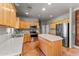 Modern kitchen featuring wood cabinets, stainless steel appliances, and a central island with countertop seating at 640 E Desert Canyon Rd, Wickenburg, AZ 85390
