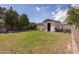 A private backyard features a shed, covered seating area, mature trees, and a lush lawn at 6854 W Wagoner Rd, Glendale, AZ 85308