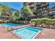 Community pool and hot tub area, surrounded by brick pavers and lush landscaping at 7161 E Rancho Vista Dr # 6002, Scottsdale, AZ 85251