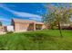 This backyard features a covered patio, a manicured lawn, trees and partial shade at 8637 E Olla Ave, Mesa, AZ 85212