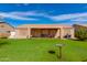 This backyard boasts a covered patio, a well-maintained lawn, trees and a gas BBQ at 8637 E Olla Ave, Mesa, AZ 85212