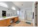 Bright bathroom featuring double sinks, a bathtub, and glass shower enclosure at 8637 E Olla Ave, Mesa, AZ 85212