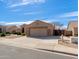 Side view of a single-story home showing the driveway and well-maintained landscaping at 8637 E Olla Ave, Mesa, AZ 85212