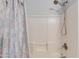 Close-up of a tiled shower with a modern shower head and shower curtain in this home at 8637 E Olla Ave, Mesa, AZ 85212