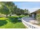 Lush backyard with mature citrus trees, green grass, and a curved patio for outdoor gatherings at 10825 W Caron Dr, Sun City, AZ 85351