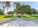 Beautiful backyard with mature trees, lush green lawn, and a charming stone patio area for outdoor enjoyment at 10825 W Caron Dr, Sun City, AZ 85351