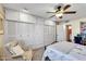 Spacious bedroom with a large closet, ceiling fan, and cozy chair near the window for relaxing at 10825 W Caron Dr, Sun City, AZ 85351