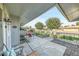 Charming covered patio featuring stone flooring, outdoor seating, and views of the well-maintained yard at 10825 W Caron Dr, Sun City, AZ 85351