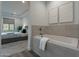 Modern bathroom featuring a soaking tub with gray tile surround and artwork at 11673 N 136Th St # 1013, Scottsdale, AZ 85259