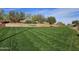 Landscaped Trilogy entrance featuring vibrant flowers and manicured lawn at 13211 W Hummingbird Ter, Peoria, AZ 85383