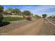 Landscaped Trilogy entrance with stone wall, flowers and trees at 13211 W Hummingbird Ter, Peoria, AZ 85383