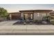 Charming home showcasing a well-manicured front yard, desert landscaping, stone accents, and a two-car garage at 13211 W Hummingbird Ter, Peoria, AZ 85383