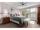 Bright main bedroom features a tufted headboard, ceiling fan, and large windows offering plenty of natural light at 13211 W Hummingbird Ter, Peoria, AZ 85383