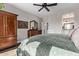 Main bedroom with wood flooring, dresser, ceiling fan and an ensuite bathroom at 13211 W Hummingbird Ter, Peoria, AZ 85383