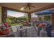 Inviting covered patio featuring stylish outdoor seating, ceiling fan and a view of the landscaped yard and spa at 13211 W Hummingbird Ter, Peoria, AZ 85383