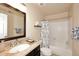 Bright bathroom featuring a tub-shower combo, granite countertops, and white tiled walls at 13642 S 42Nd St, Phoenix, AZ 85044