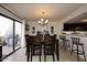 Bright dining room featuring a modern chandelier, adjacent to the kitchen and sliding glass doors at 13642 S 42Nd St, Phoenix, AZ 85044