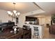 Open-concept dining room with a chandelier, adjacent to a kitchen bar featuring dark cabinets and stainless steel appliances at 13642 S 42Nd St, Phoenix, AZ 85044