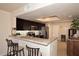 Kitchen bar with granite countertops, bar stool seating, modern appliances, and sleek dark wood cabinets at 13642 S 42Nd St, Phoenix, AZ 85044