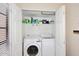 Laundry closet with stacked washer and dryer, shelving for supplies, and double doors for easy access at 13642 S 42Nd St, Phoenix, AZ 85044