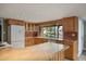 Traditional eat-in kitchen with wood cabinetry, tile backsplash, and a bright view of the backyard pool at 1407 E Laguna Dr, Tempe, AZ 85282