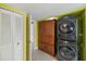 A well organized laundry room with white double doors and stacked washer dryer unit at 1407 E Laguna Dr, Tempe, AZ 85282