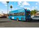 A Blue Orbit bus against a bright sky near homes and palm trees at 1407 E Laguna Dr, Tempe, AZ 85282