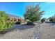 Well-manicured backyard featuring desert landscaping, mature trees, and solar panels for eco-friendly living at 14617 W Windcrest Dr, Sun City West, AZ 85375