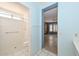 Bright bathroom featuring shower, toilet, grab bar, with doorway leading to the bedroom at 14617 W Windcrest Dr, Sun City West, AZ 85375