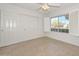 Well-lit bedroom featuring window with shutters, and a large closet with multiple sliding doors at 14617 W Windcrest Dr, Sun City West, AZ 85375