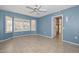 Bedroom featuring plantation shutters on the window, ceiling fan, and tile floors with a door leading to the outside at 14617 W Windcrest Dr, Sun City West, AZ 85375