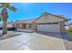 Suburban home showcasing a wide garage door and meticulous desert landscaping, set under a vibrant, cloudless sky at 14617 W Windcrest Dr, Sun City West, AZ 85375